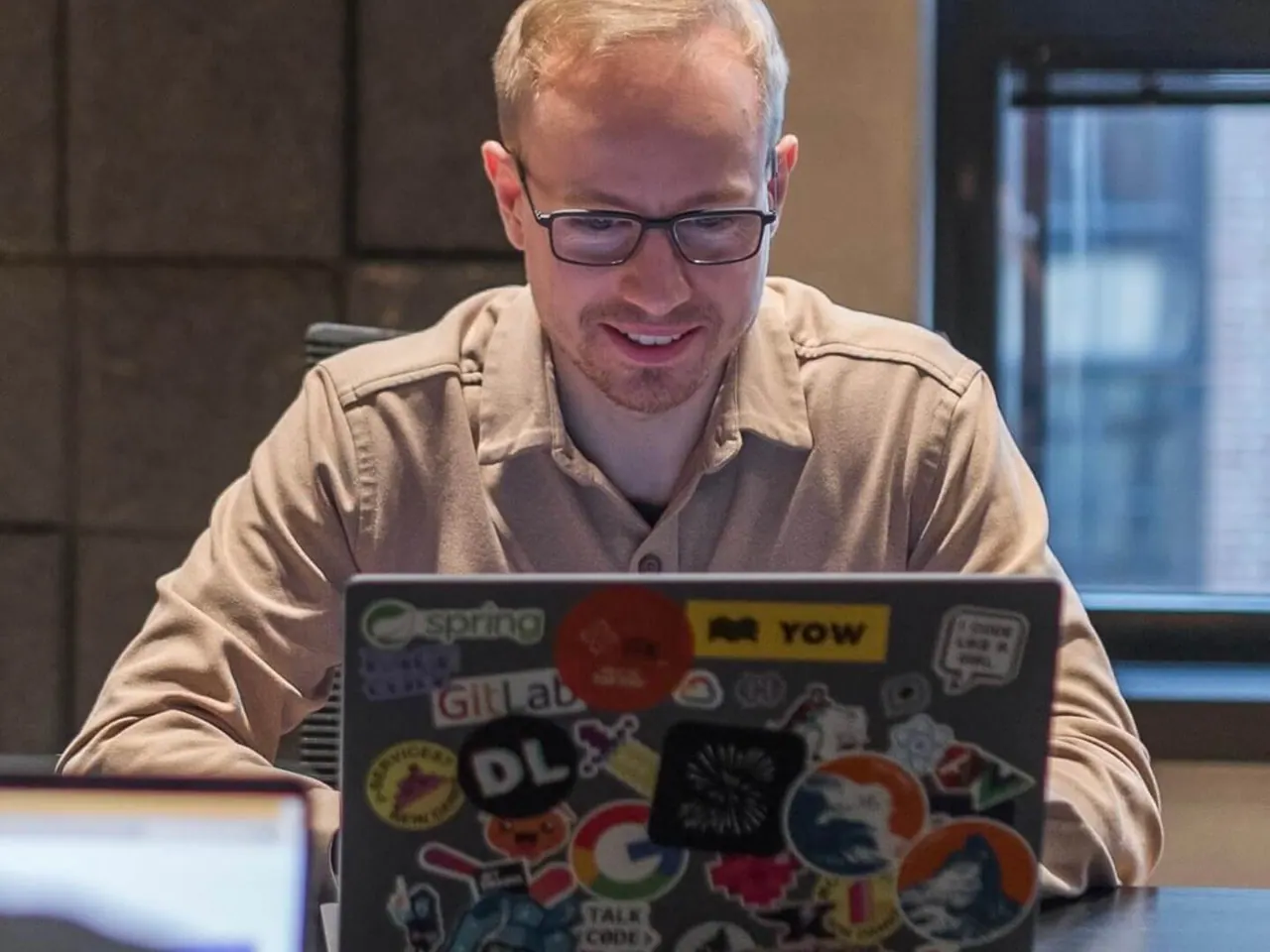 An engineer working with an AI-assisted development setup at a conference table